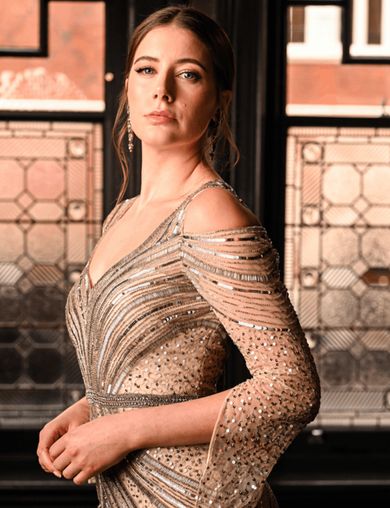 Gold and silver embellished Gill Harvey dress featuring cold-shoulder detailing, sheer sleeves, and intricate beading in a sculpted, art deco-inspired pattern